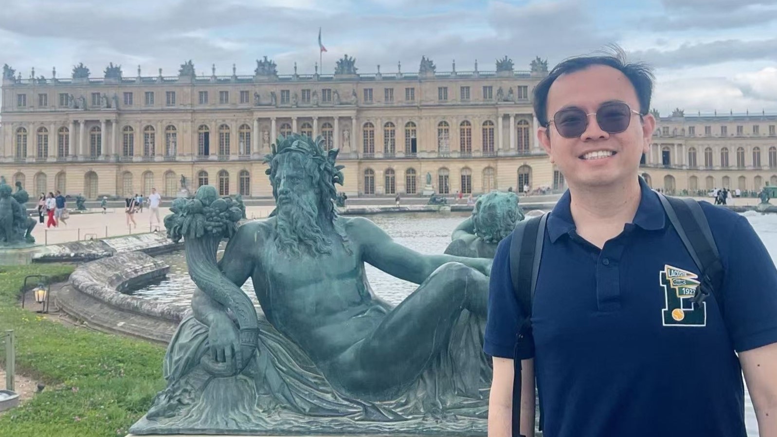Man smiling in front of fountain