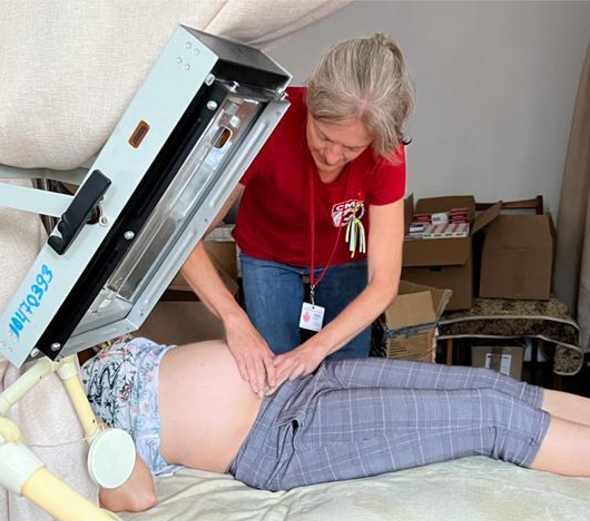 Female physician presses hands on pregnant patient's belly in medical tent
