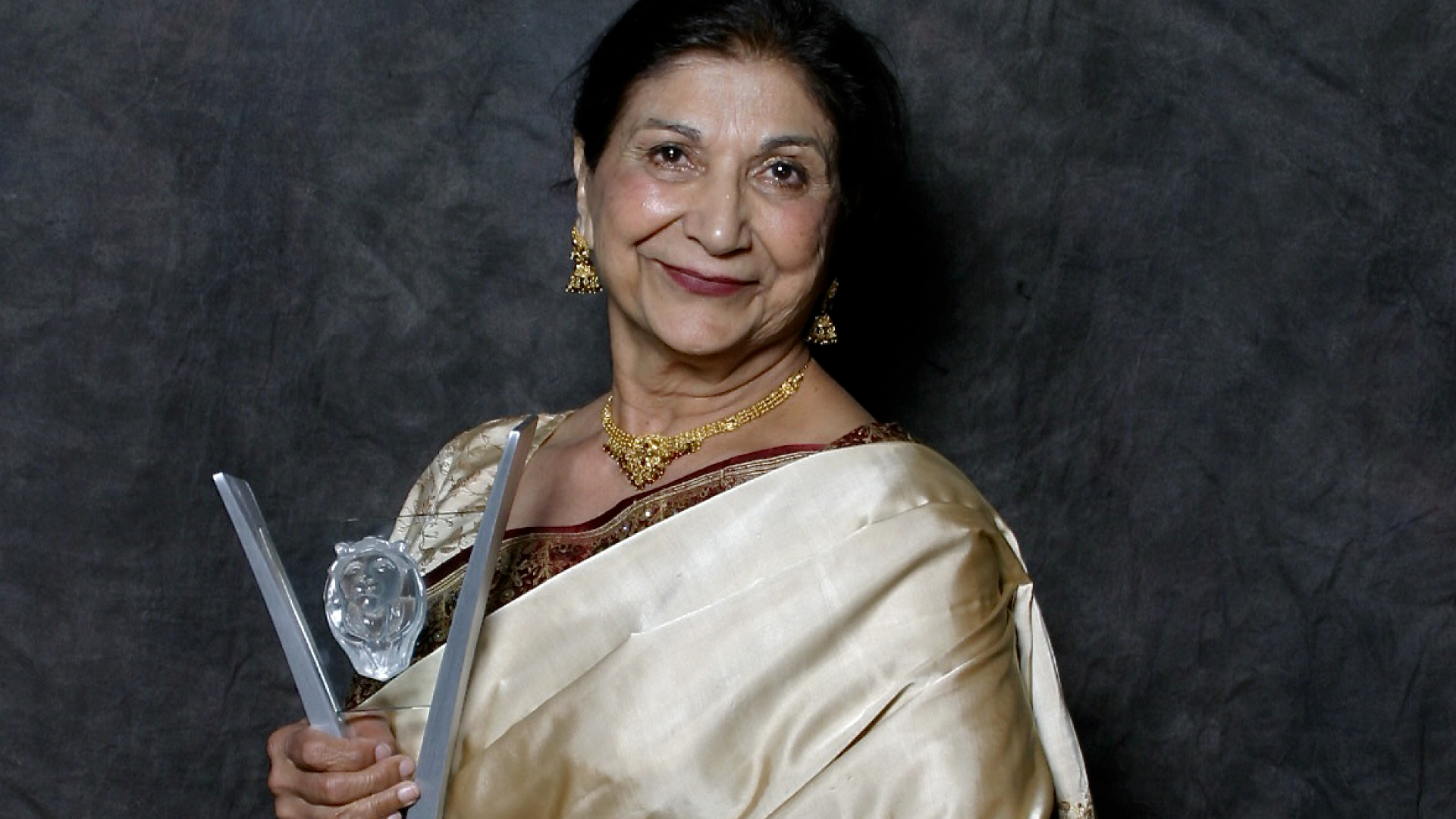 Actor Balinder Johal in a sari posing with an award