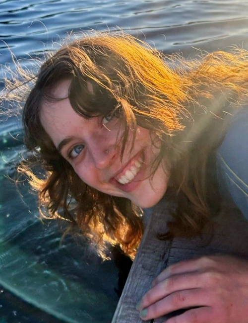 Sophia Collins leaning over a dock next to a lake