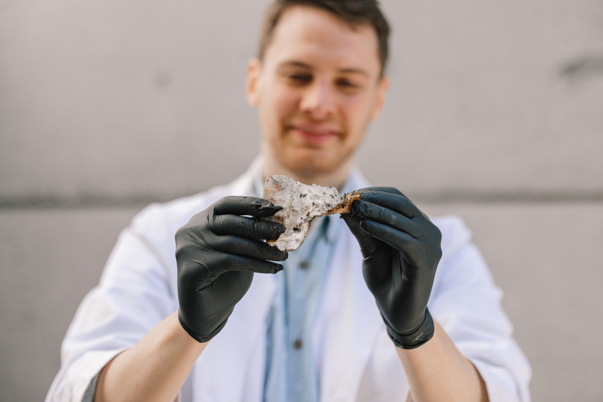 Scientist holds takeout container that is decomposing