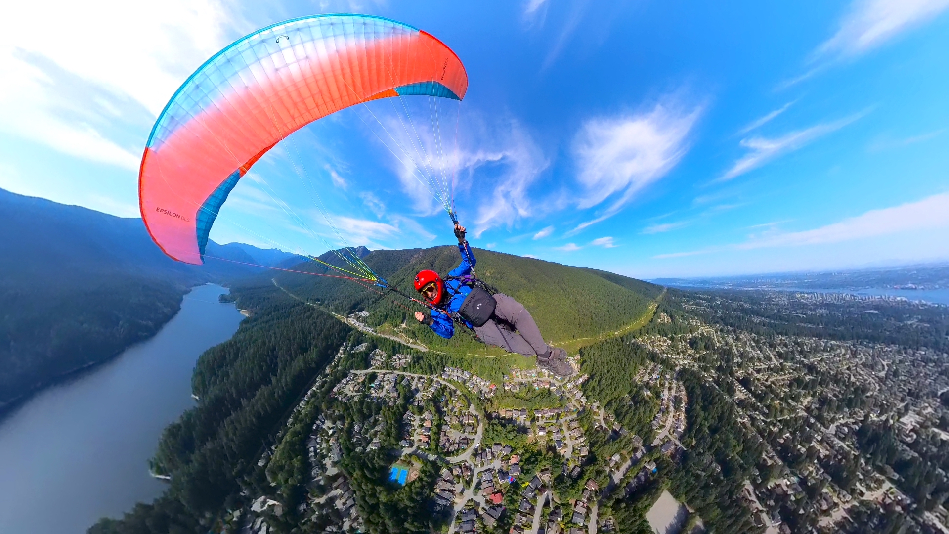 Bill Nikolai paragliding with a panoramic view of Grouse Mountain beneath him