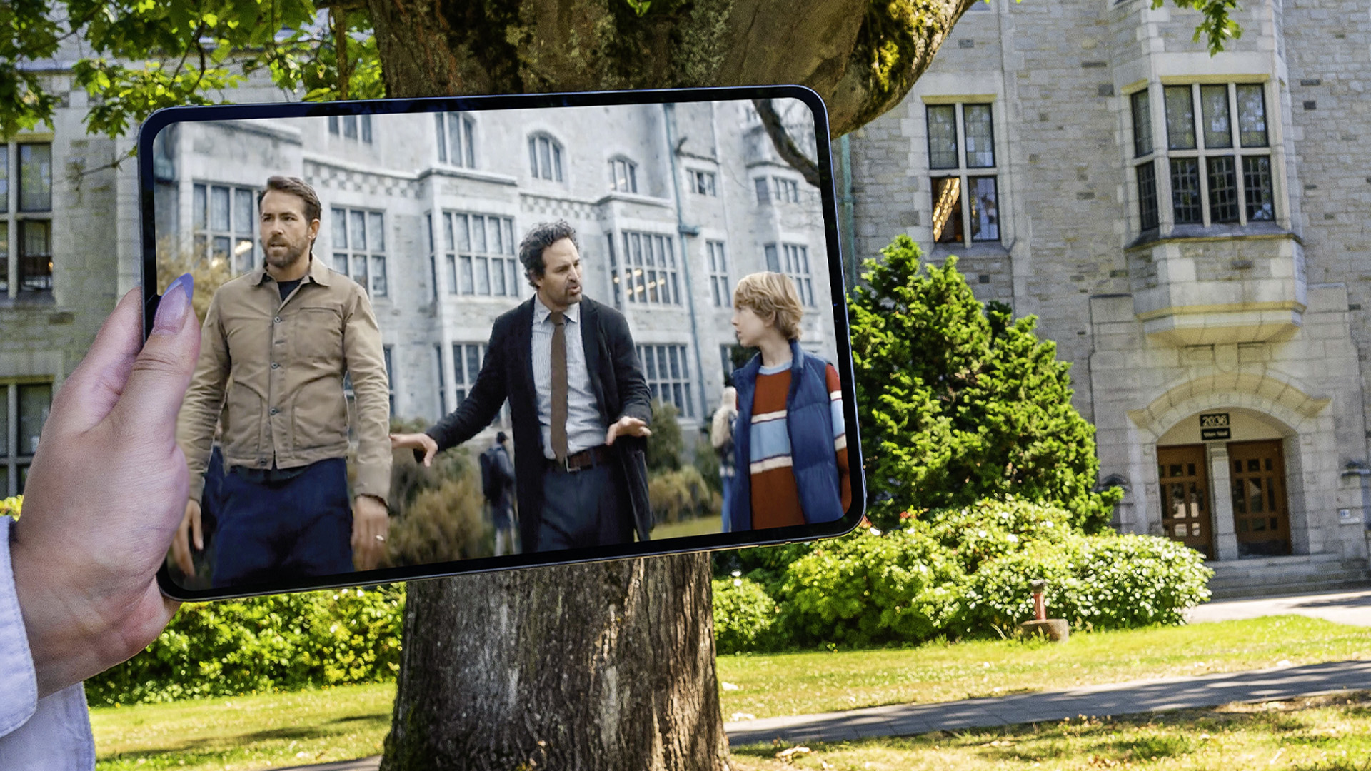 Shot of an iPad screen held over the Chemistry building. On the iPad screen is a shot from the Adam Project outside Chemistry building.