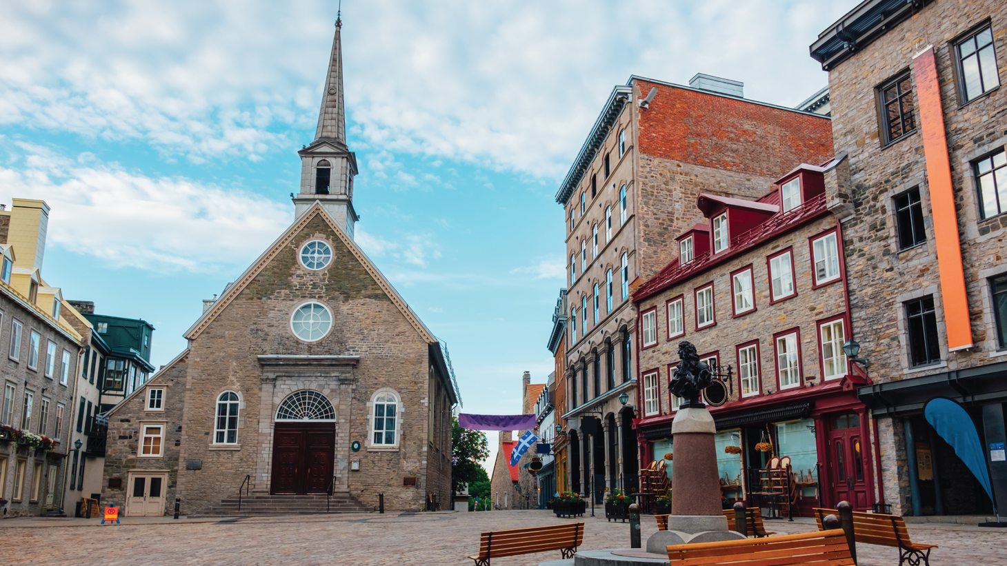 A cobblestone courtyard with a squat stone church at the center