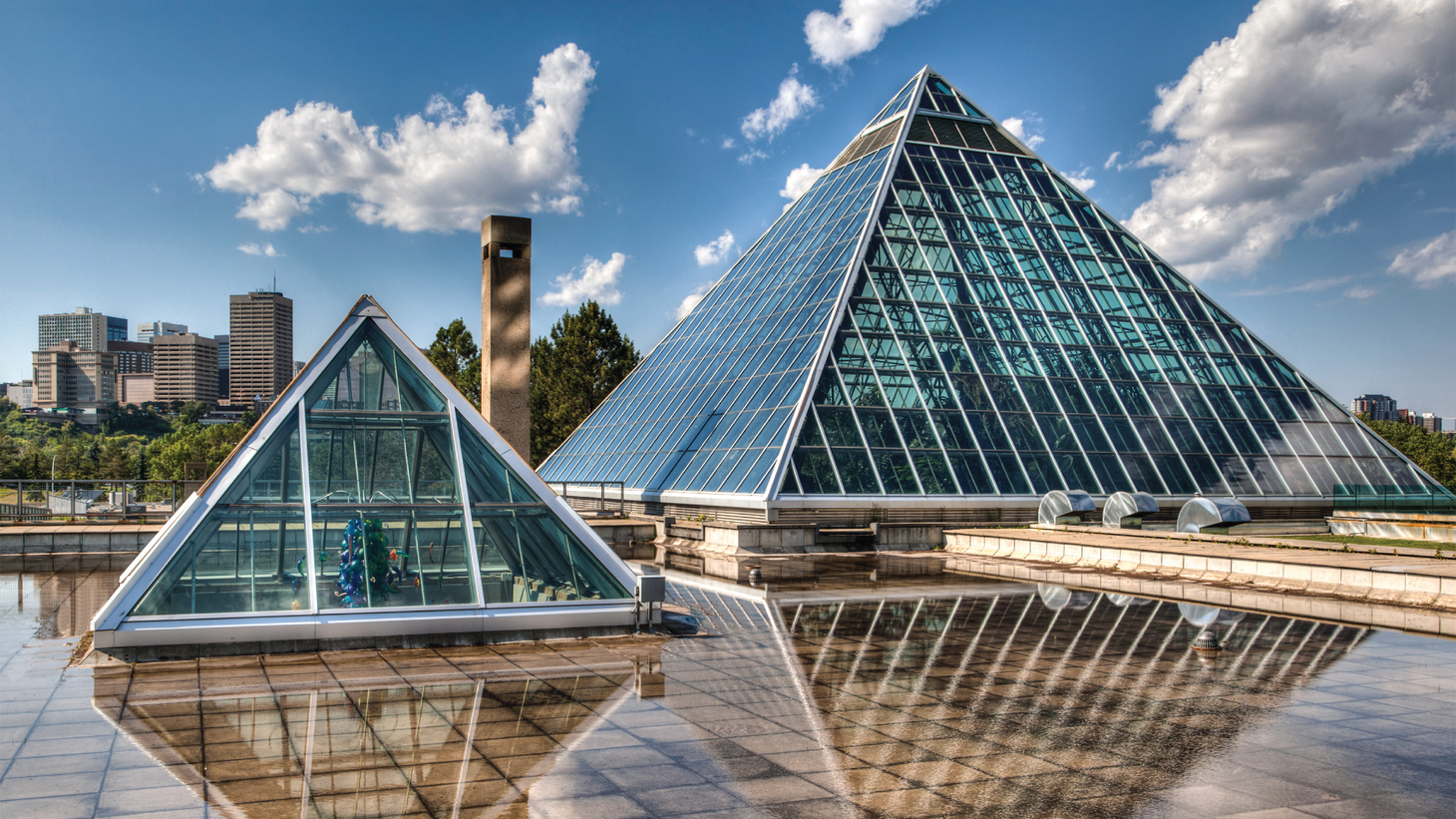 Two glass pyramids stand above a reflecting pool