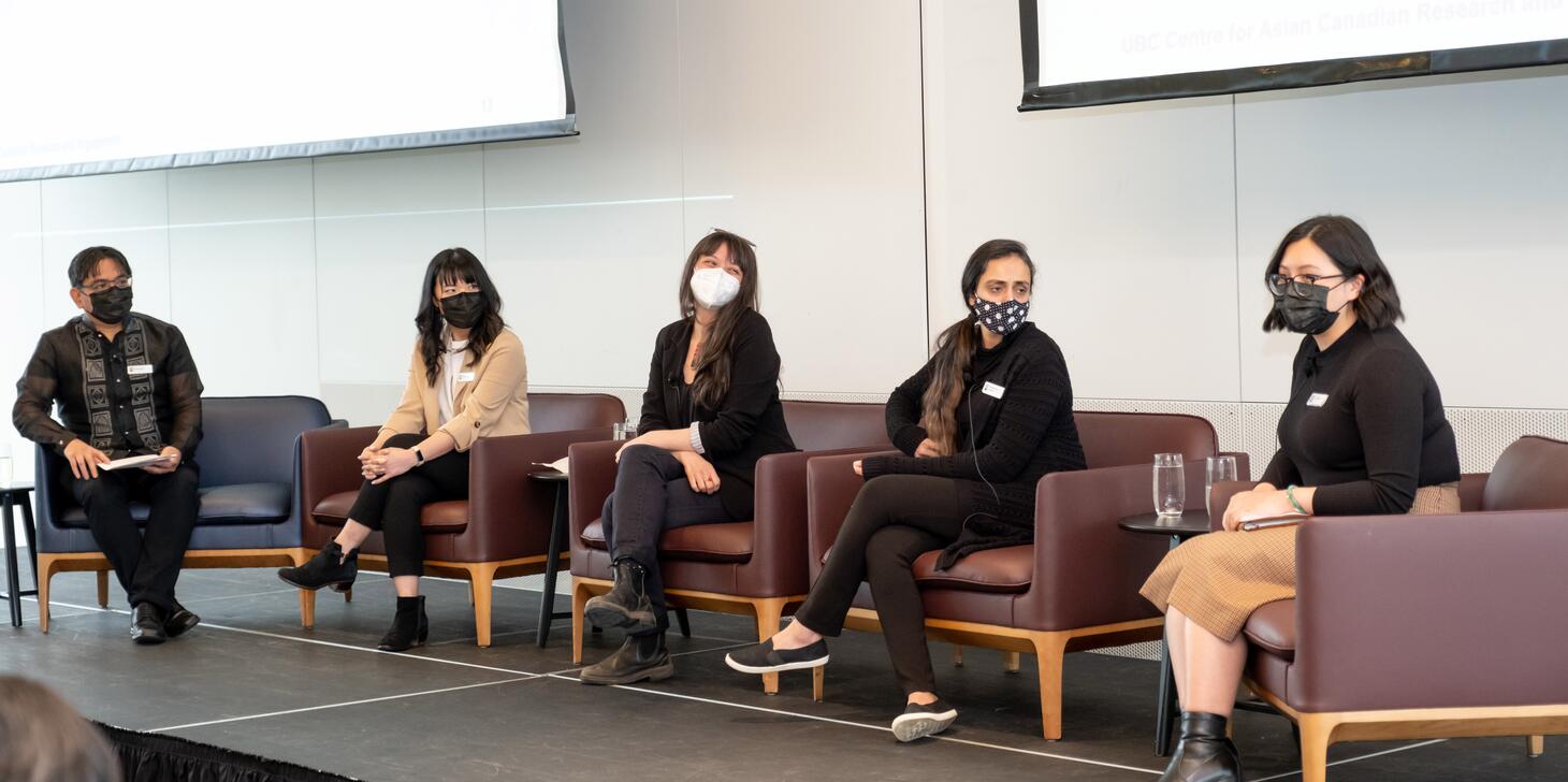 A panel of Asian Canadian speakers seated on a stage