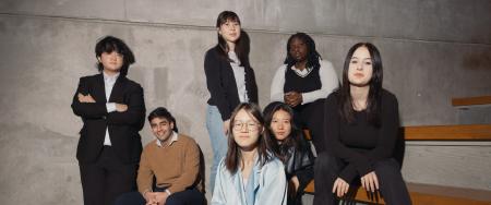 Indoor shot of six students sitting on tiered benches