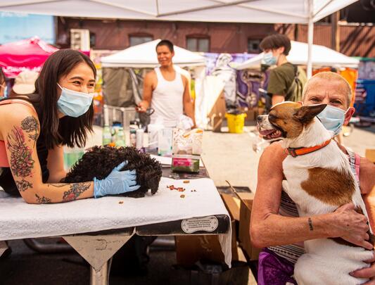 Two women, each holding a dog, at the CVO Pet Fair People Care event on June 28, 2021