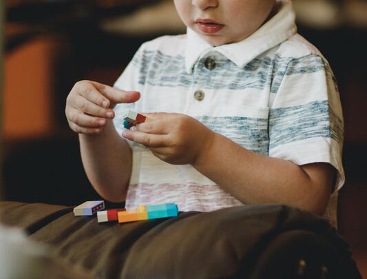 Child playing with lego pieces