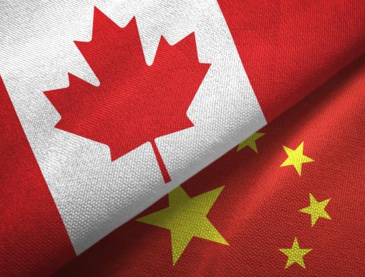 A portion of the Canada and China flags, overlapping each other.
