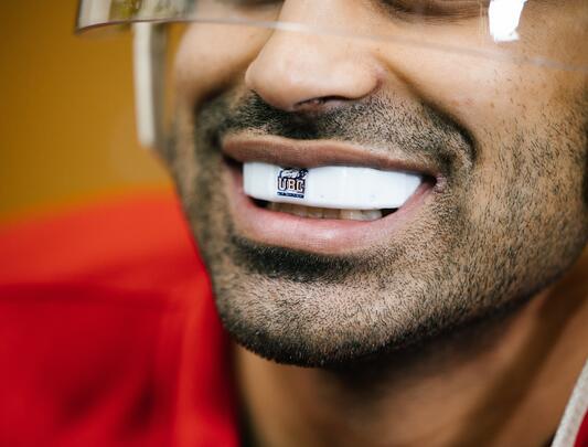 Close-up shot of a UBC hockey player wearing the high-tech mouthguard showing UBC Thunderbirds logo