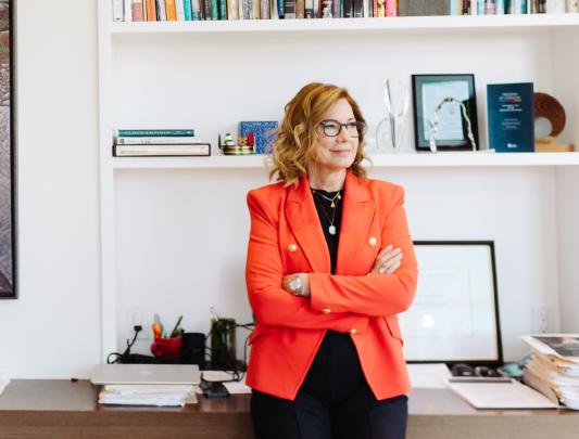 Elizabeth Denham standing in an office with her arms crossed