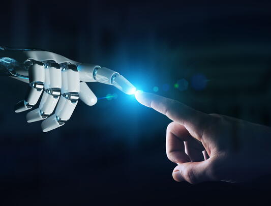 Robot finger touching human finger, with light at point of contact
