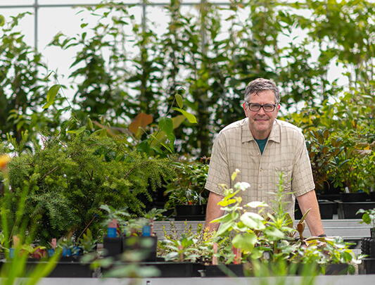 Kevin Kubeck standing among plants in a nursery