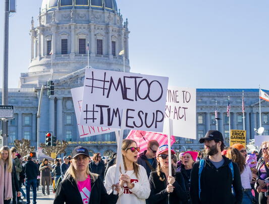 Protesters holding signs in front of San Francisco city hall