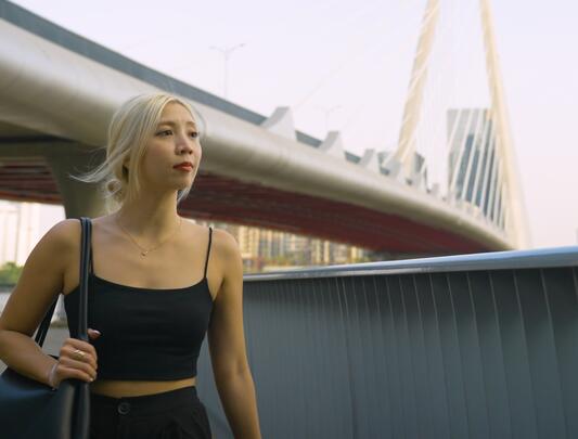 Marina Tran-Vu walking outside with a bridge in the background