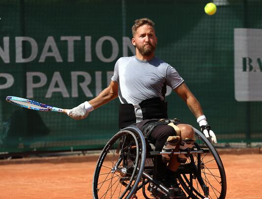 Rob Shaw playing tennis on a clay court