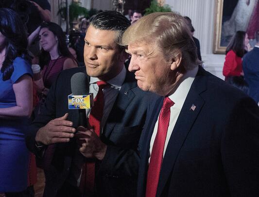 President Donald Trump with Pete Hegseth speak into microphone