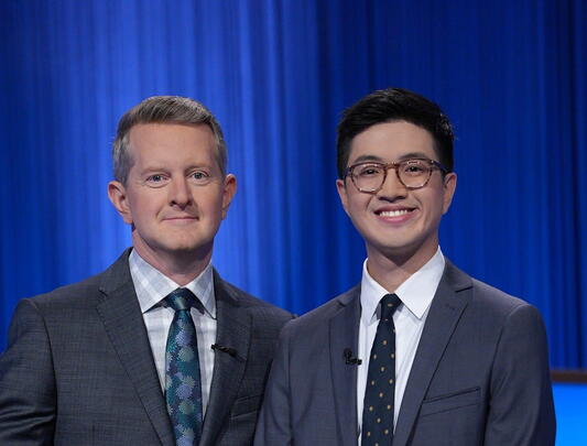 Jeopardy host stands beside winner on set
