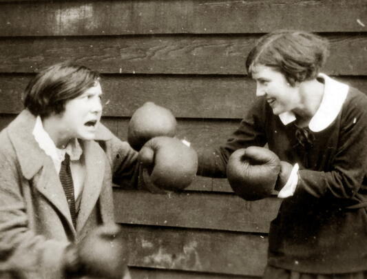 Two students pretend to box with boxing gloves