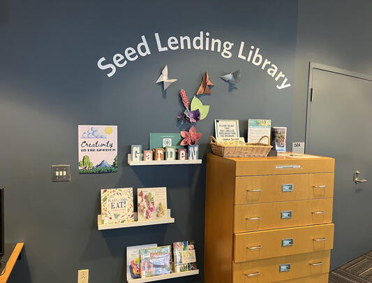 Shelves and dresser below "Seed Lending Library" sign