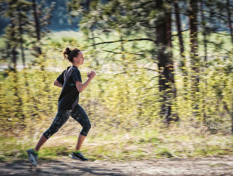 Woman running on a trail in the forest