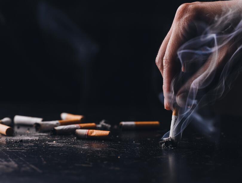 Photo of a hand putting out a cigarette.