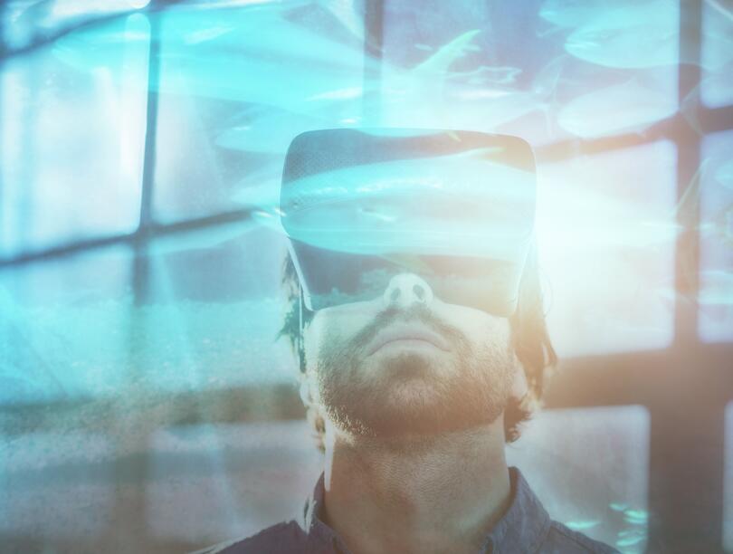 Photo of a man looking up with a VR headset on.