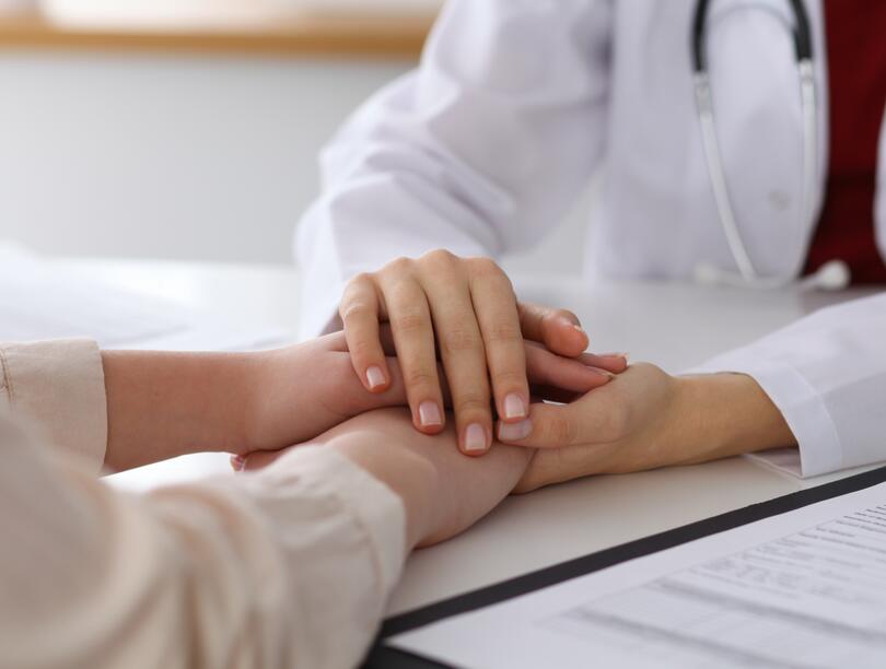 Hand of doctor reassuring her female patient