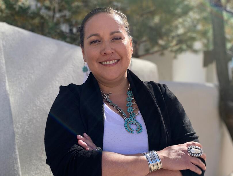 Headshot of Dr. Kimberly Huyser, standing outside, with arms crossed, smiling