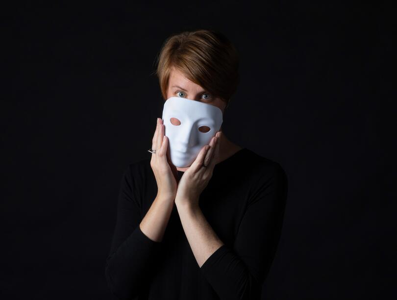 Dr. Leanne ten Brinke holding a white mask over her face