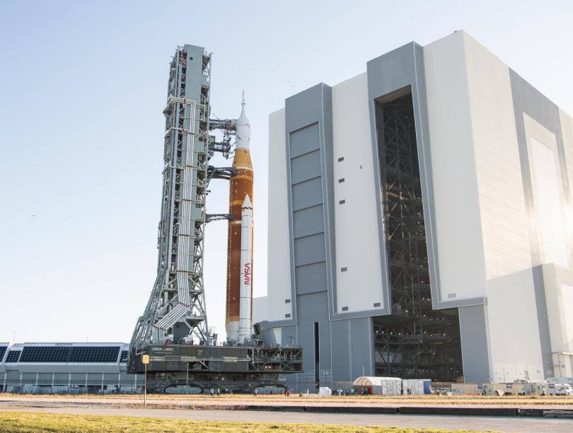 NASA rocket with spacecraft at launch complex on sunny day with clear skies