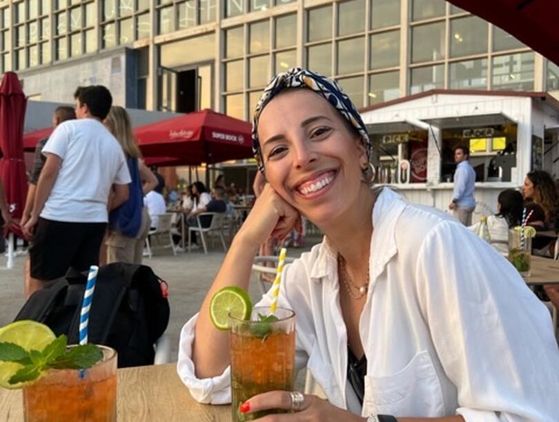 Robyn Freiheit seated at a table outdoors, enjoying a beverage