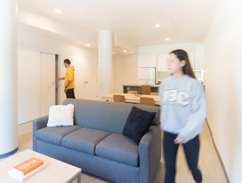 Man checks closet while woman moves through apartment