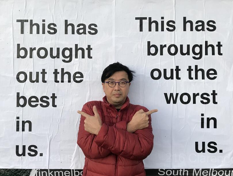 Dave standing in front of street art that says on one side: "This has brought out the best in us." And on the other: "This has brought out the worst in us."