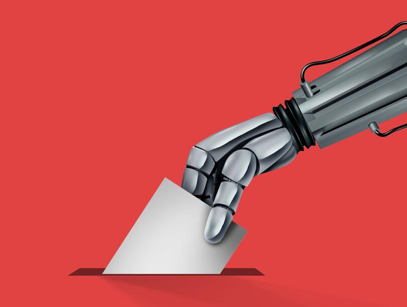A robotic arm slips a ballot into a slot