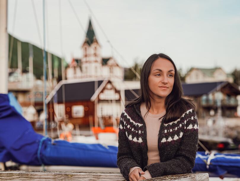 Charla Basran at Húsavík Harbor with a church in the background