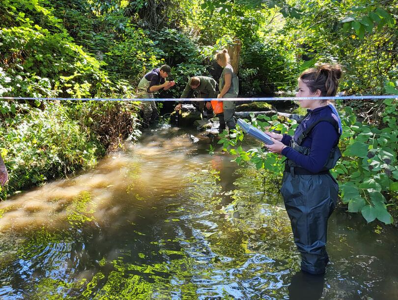 Five people stand in river 