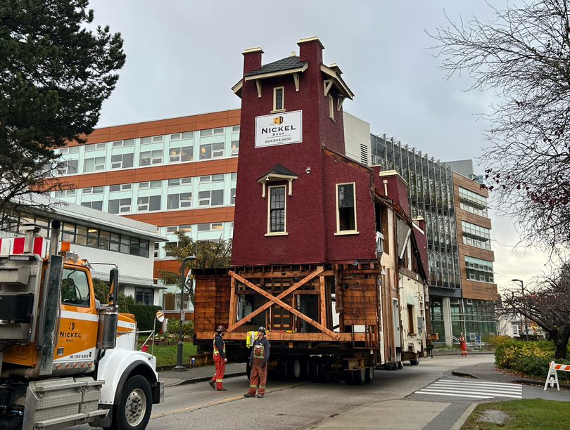 Traditional fire hall being carried on top of flatbed truck