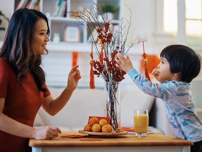 Woman and child at a table decorated with Lunar New Year colours