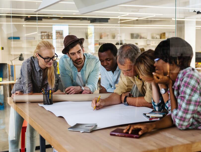Group of people in an office having a meeting at a table