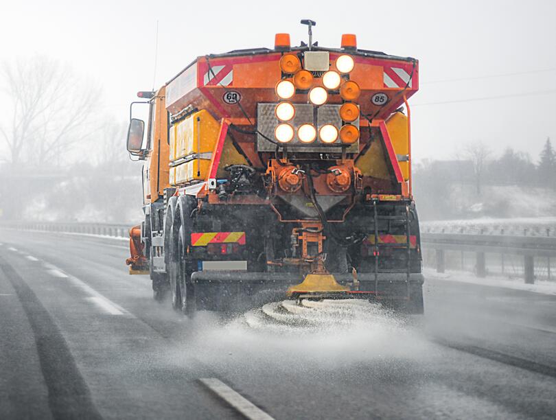 Truck spraying salt onto road in fog 