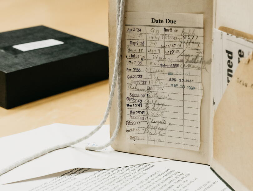 Open book with due date log beside box and papers