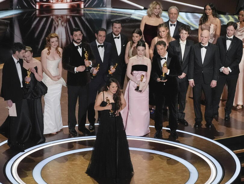 Samantha Quan giving her acceptance speech with the cast and team of her Oscar-winning film behind her