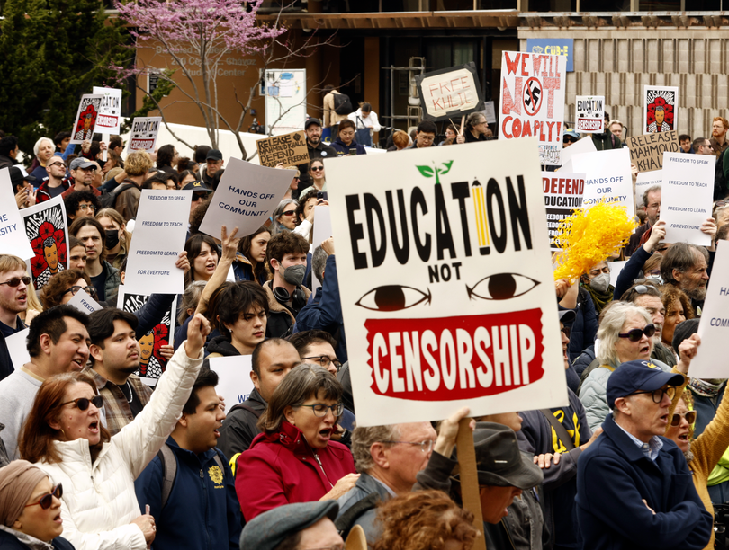 Marching protesters holding signs 