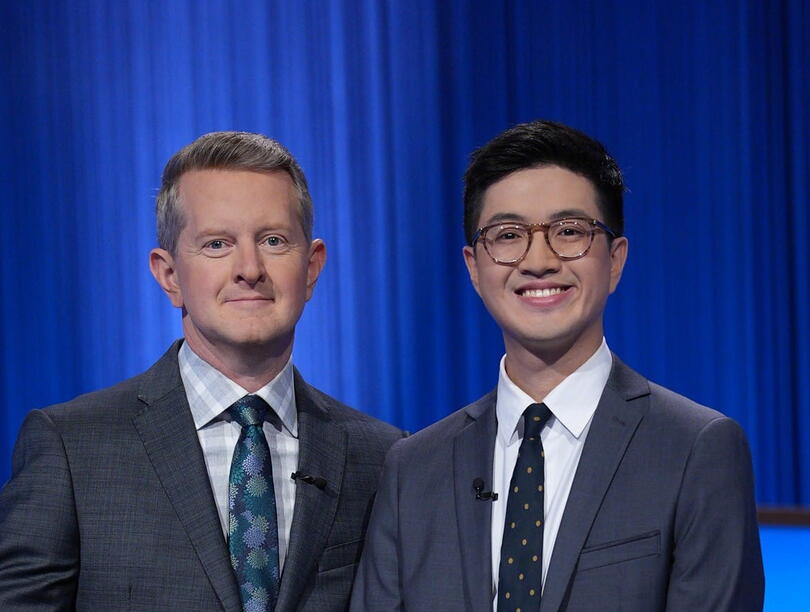Jeopardy host stands beside winner on set