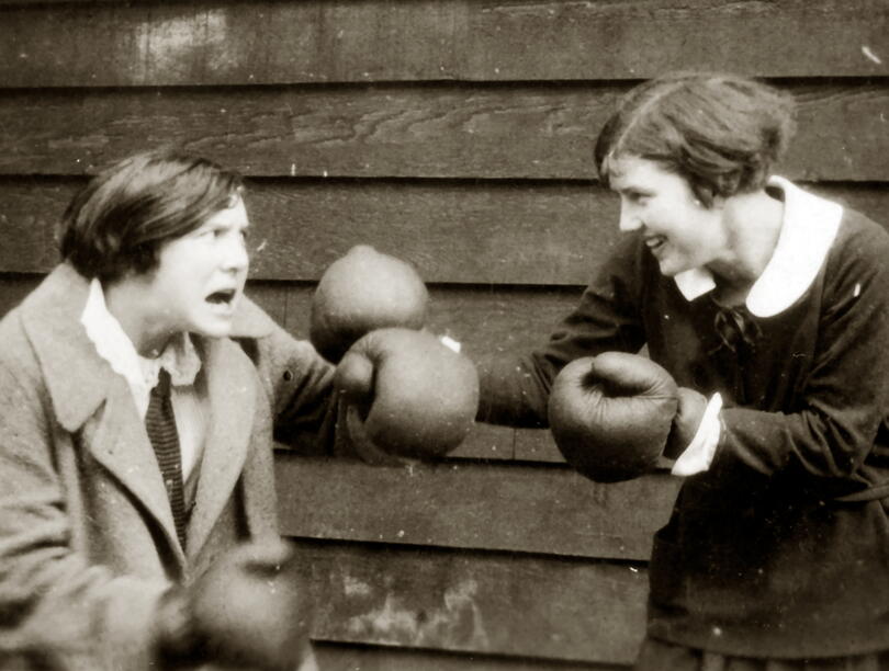 Two students pretend to box with boxing gloves