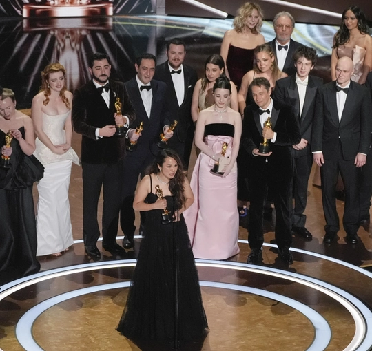 Samantha Quan giving her acceptance speech with the cast and team of her Oscar-winning film behind her