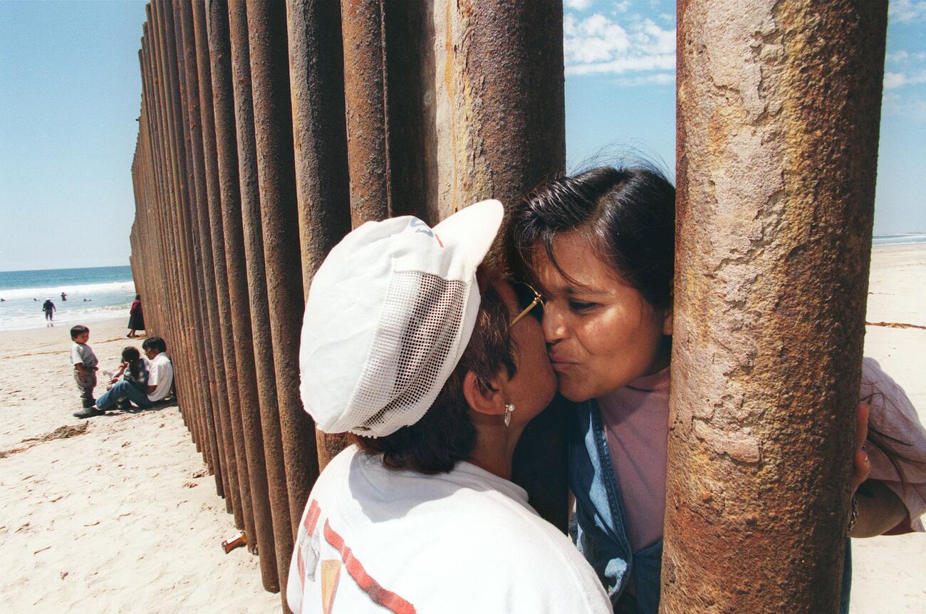 BETWEEN BORDERS: When one in every 110 people on Earth has been forced to flee, some nations respond with barriers, like “the wall” between the United States and Mexico. Photo: Getty Images, Hector Mata