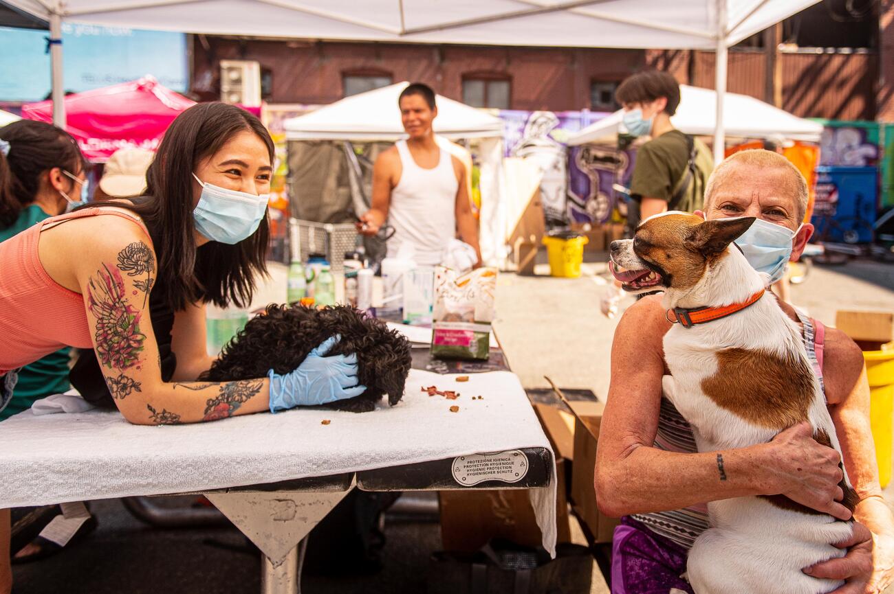Two women, each holding a dog, at the CVO Pet Fair People Care event on June 28, 2021